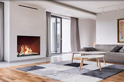 Contemporary living room featuring a Flare Traditional 46” fireplace with a herringbone red brick interior, framed in a minimalist white wall beside floor-to-ceiling windows, with modern gray furniture, abstract artwork, and a geometric area rug.